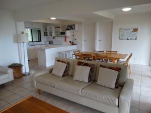 a living room with a couch and a kitchen and a table at The Beach House, Kangaroo Island in Baudin Beach