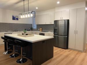 a kitchen with white cabinets and a stainless steel refrigerator at Keystone in Dinner Plain