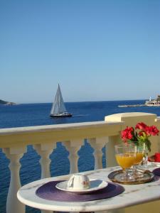 a table on a balcony with a sailboat in the ocean at Tassos Apartments II in Agia Marina