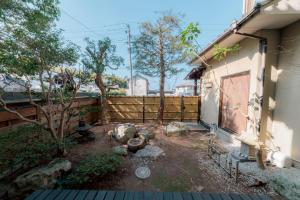 a backyard of a house with a fence at めぐり宿 庵結 in Shimonoseki +35 photos