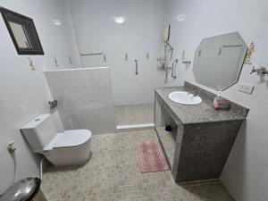 a bathroom with a toilet and a sink and a mirror at Your space surrounded by Nature in Ban Mai Salae +11 photos