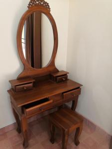 a wooden dressing table with a mirror and a stool at Your space surrounded by Nature in Ban Mai Salae