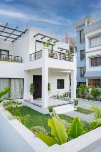 a white house with plants in front of it at Villa Aura in Siliguri