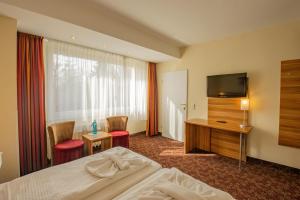 a hotel room with a bed and a television at Ferien Hotel Rennsteigblick in Friedrichroda +81 photos