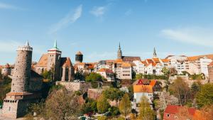 an old city with towers and buildings on a hill at Weinschlafwagen Bautzen in Bautzen