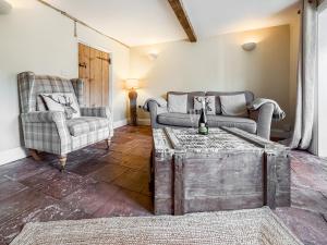 a living room with two chairs and a couch and a table at Rosemary Cottage in Mattishall