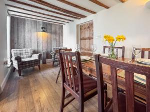 a dining room with a wooden table and chairs at Rosemary Cottage in Mattishall +14 photos