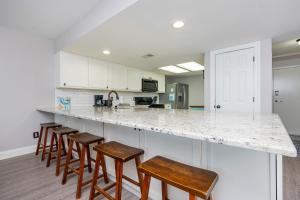 a kitchen with a counter with stools in it at Wind Drift 604S condo in Orange Beach
