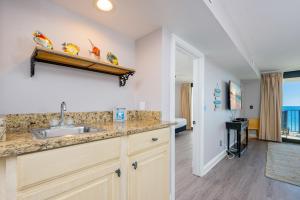 a kitchen with a sink and a room with a bed at Wind Drift 604S condo in Orange Beach