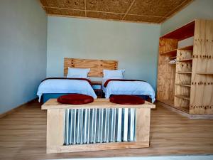 two beds in a room with two red pillows at Tsoelike River Lodge in Sehlabathebe