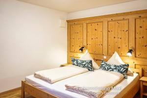a bedroom with a bed with a wooden headboard at Ferienwohnung Maxl in Schwangau
