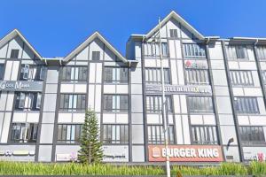a large white building with a sign in front of it at Cameron Green Inn Hotel in Brinchang
