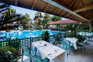 a restaurant with tables and chairs next to a pool at Marvıda Hotel Akman Park in Kemer