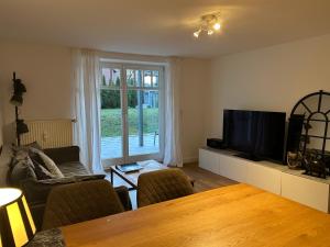 a living room with a table and a flat screen tv at Seepferdchen in Timmendorfer Strand