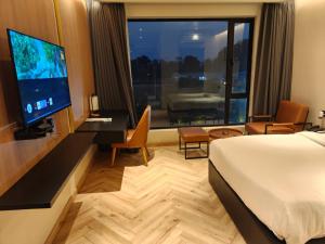 a hotel room with a bed and a flat screen tv at Vintclub Resort in Lucknow