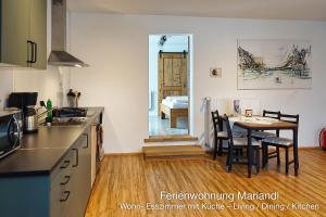 a kitchen with a table and a dining room at Ferienwohnung Mariandl in Schwangau