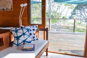 a bench with a pillow and a lamp and a window at Georgina's place, Kangaroo Island in Brown Beach