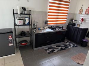 a kitchen with a stove and a counter top at Teratak Shamar in Kampong Tebok Pulai