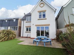 a blue picnic table in front of a house at Farne Cottage in Beadnell