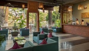 a restaurant with blue chairs and a bar at La Rivière d' Angkor Resort in Siem Reap