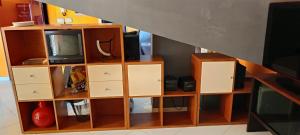 a wooden book shelf with a tv on it at Chalet Nautilus in San Mango Piemonte +3 photos