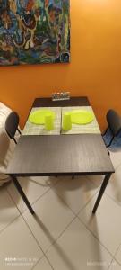 a table with two green chairs and a painting at Chalet Nautilus in San Mango Piemonte