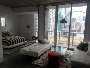 a bedroom with a bed and a couch and a window at Downtown Miami Deluxe Apartment in Miami