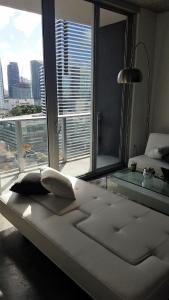 a white bed in a room with a large window at Downtown Miami Deluxe Apartment in Miami
