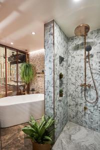 a bathroom with a tub and a plant at THE MOMENT, Chiang Mai in Chiang Mai