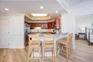 a kitchen with a table and chairs in a room at Phoenix on the Bay 1309 in Orange Beach