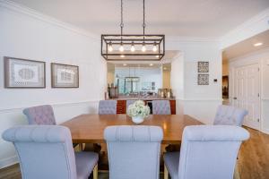 a dining room with a wooden table and blue chairs at Phoenix on the Bay 1309 in Orange Beach