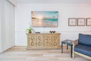 a living room with a couch and a tv on a wall at Phoenix on the Bay 1309 in Orange Beach