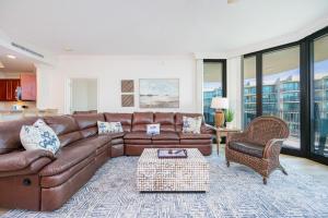 a living room with a brown leather couch and chairs at Phoenix on the Bay 1309 in Orange Beach