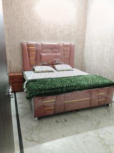 a bedroom with a large bed with a pink headboard at Hotel Blue Heaven in Karnal