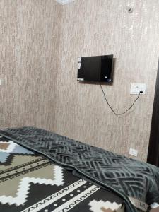 a room with a tv on the wall at Hotel Blue Heaven in Karnal