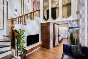 a living room with a staircase and a television at THE MOMENT, Chiang Mai in Chiang Mai