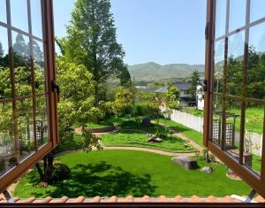 a view of a garden from a window at Star Peak Villa 黒川 in Minamioguni