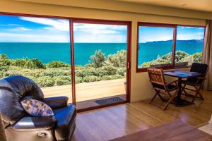 a living room with a view of the ocean at Sunrise Apartment - Golden Bay in Onekaka
