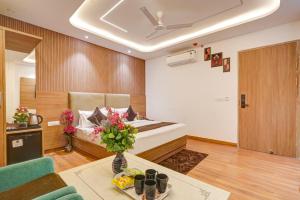 a room with a bed and a table with flowers at Olive Aero Suites Plaza Inns Near Delhi International Airport in New Delhi