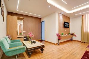 a waiting room with a green chair and a table at Olive Aero Suites Plaza Inns Near Delhi International Airport in New Delhi +37 photos