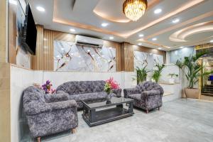 a living room with two couches and a tv at Olive Aero Suites Plaza Inns Near Delhi International Airport in New Delhi