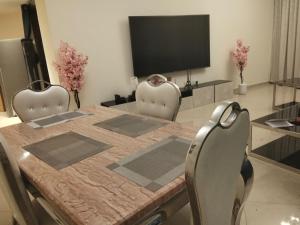 a dining room table with two chairs and a television at imperial homes 2 in Ajman 