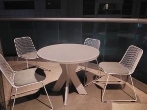 a white table with four chairs around it at imperial homes 2 in Ajman 