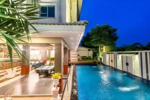 a swimming pool in the backyard of a house at Napheera Royal Tel in Ban Khlong Bang Krathiam