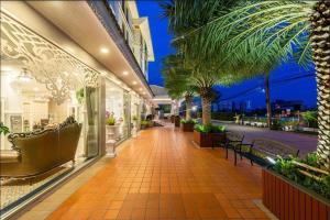 a lobby of a building with palm trees and benches at Napheera Royal Tel in Ban Khlong Bang Krathiam +62 photos