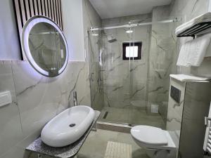 a white bathroom with a sink and a shower at Casa Cențiu II in Bran
