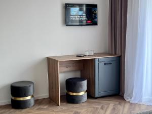 a desk with two stools and a tv on a wall at Casa Cențiu II in Bran