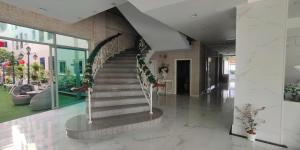 a lobby with a staircase in a building at Napheera Royal Tel in Ban Khlong Bang Krathiam