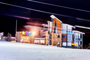 a building on a snow covered street at night at Abom Hotel in Mount Buller