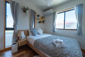 a bedroom with a bed with towels on it at Miyako Island Breeze in Miyako-jima